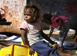 A child sits in the community centre at "Hidden Valley" aboriginal camp on the outskirts of the central Australian town of Alice Springs July 3, 2007. REUTERS/Tim Wimborne